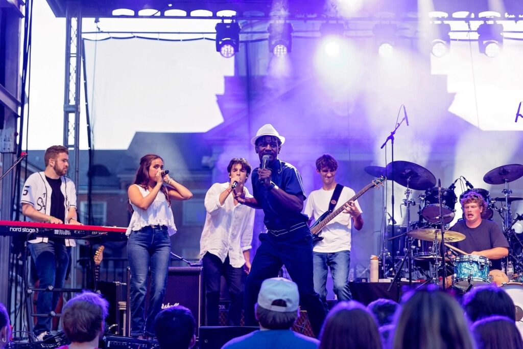 A band of young men and women on stage.
