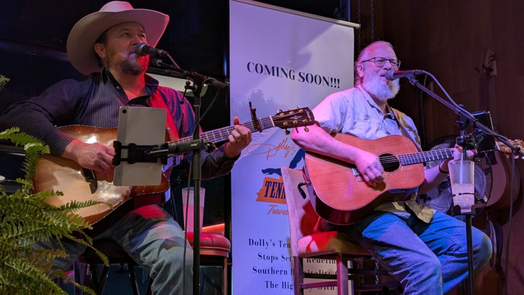 two men playing guitar
