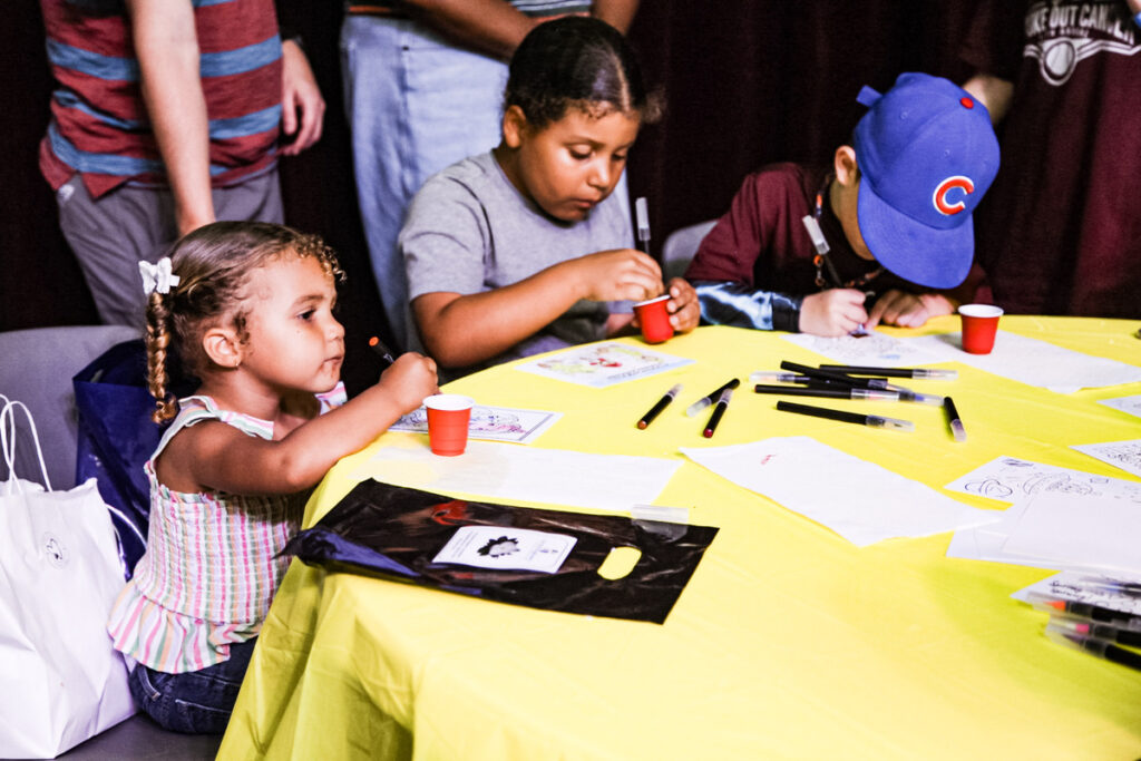 girls drawing at table.
