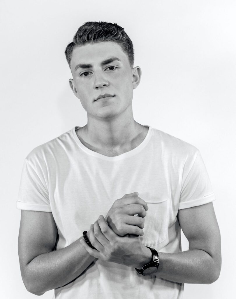 man in white t shirt holding wrist
